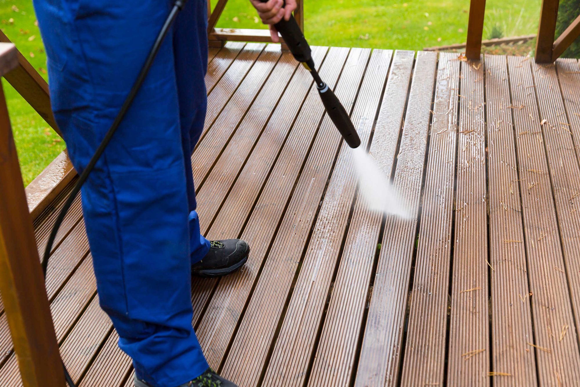 Cleaning wooden terrace with high pressure washer